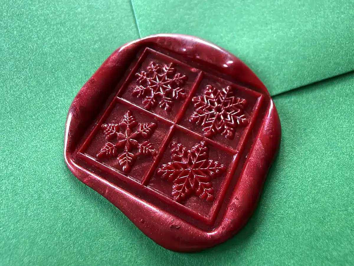 Sobre verde de la carta de Olentzero cerrado a mano con lacre rojo de copos de nieve